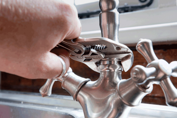 Plumber fixing pipework in a Leeds home